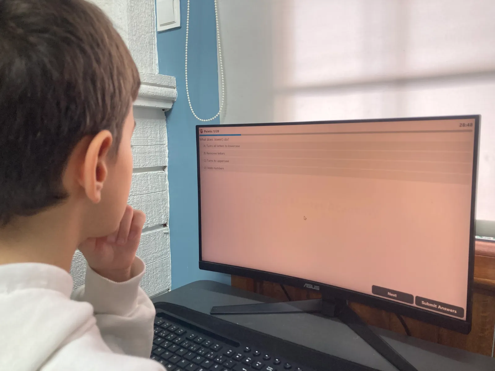 Bir öğrenci, ekrandaki Python sorusunu okuyup şıklar arasından seçim yapıyor